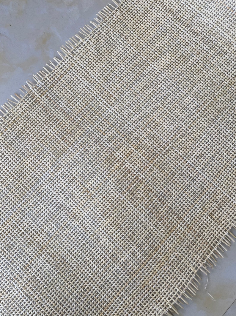 Pode incluir: Um close-up de um tecido natural tecido em uma cor bege claro. O tecido tem uma trama apertada e uma textura ligeiramente &aacute;spera.