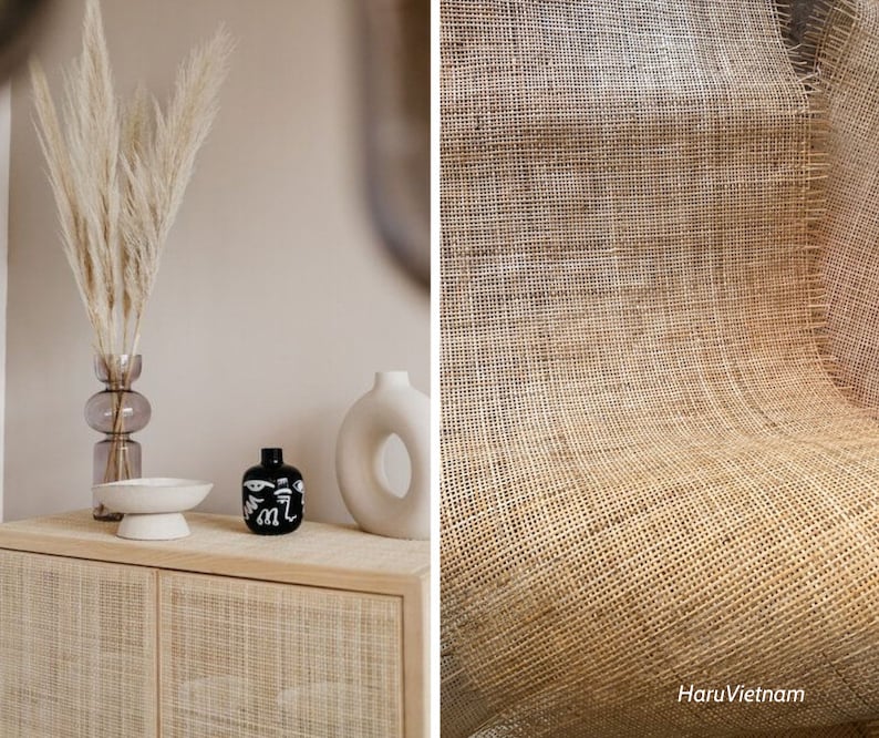 May include: A light wood cabinet with two doors, each with a woven rattan design. The cabinet is decorated with a vase of dried pampas grass, a black ceramic vase with a white design, and a white ceramic vase with a hole in the center.