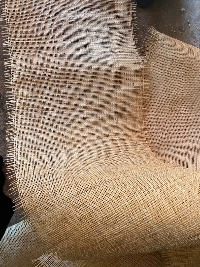 May include: A close-up of a roll of natural brown burlap fabric with a woven texture. The fabric is folded and has a frayed edge.