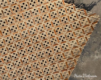 May include: A close-up of a woven cane chair seat, showing the intricate pattern of the woven material. The cane is a light brown color and the weave is tight and even.