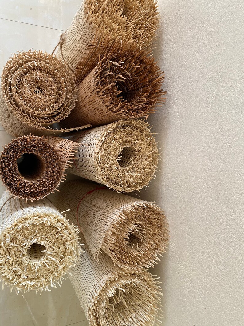 Pode incluir: Close-up de sete rolos de tecido de cana de fibra natural, um material usado para assentos de cadeiras e outras tape&ccedil;arias de m&oacute;veis. Os rolos est&atilde;o empilhados verticalmente, com o rolo superior parcialmente obscurecido pelos outros. Os rolos s&atilde;o de diferentes tamanhos e t&ecirc;m uma textura natural tecida.