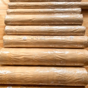 Pode incluir: Uma pilha de tubos embrulhados em papel castanho com etiquetas escritas &agrave; m&atilde;o e endere&ccedil;os. Os r&oacute;tulos incluem endere&ccedil;os em Nova Orleans, Louisiana, e nos Estados Unidos.
