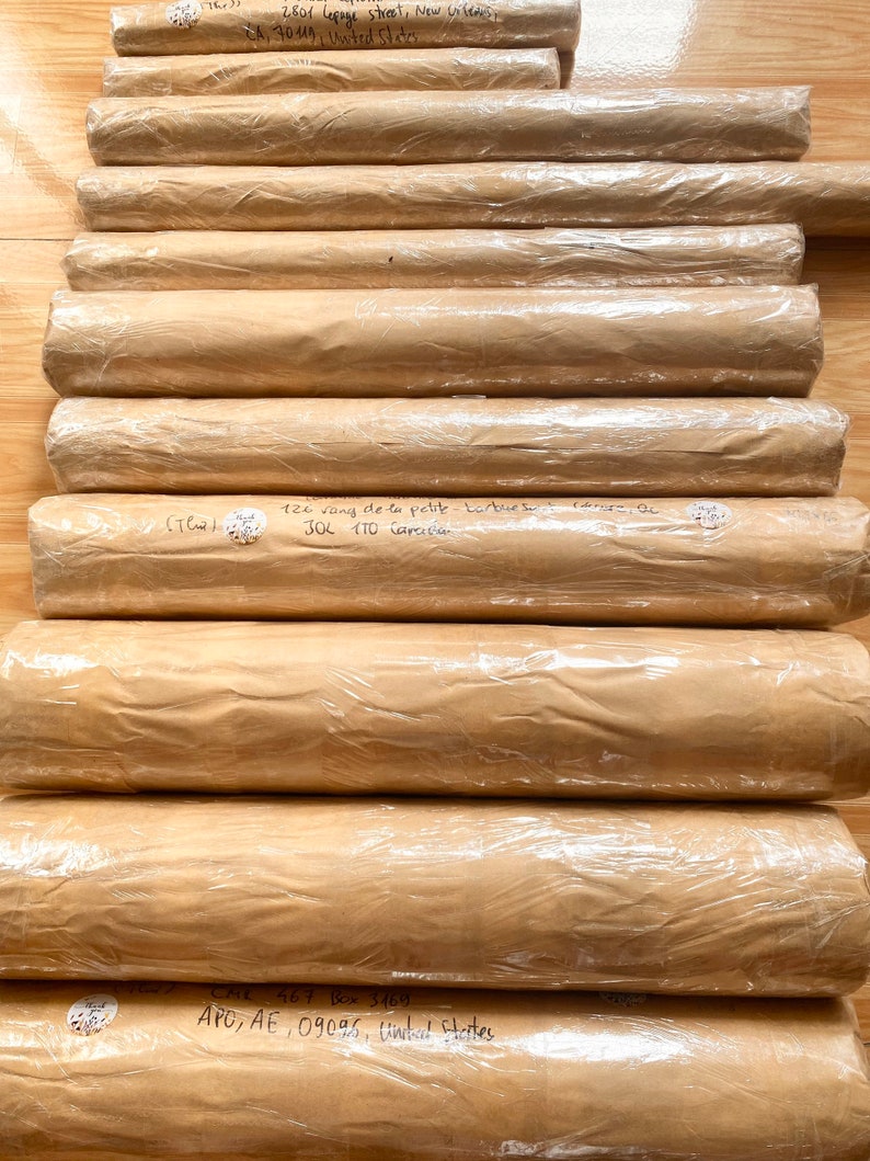 Pode incluir: Uma pilha de tubos embrulhados em papel castanho com etiquetas escritas &agrave; m&atilde;o e endere&ccedil;os. Os r&oacute;tulos incluem endere&ccedil;os em Nova Orleans, Louisiana, e nos Estados Unidos.