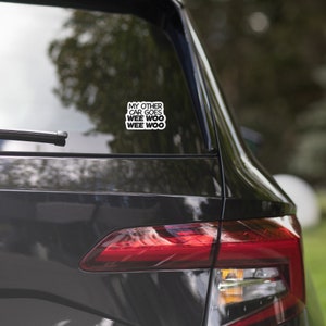 May include: A black car with a sticker on the back window that says "My other car goes wee woo wee woo".