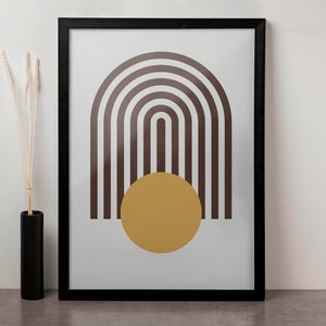 May include: A framed print with a minimalist design featuring a brown and white striped arch shape with a yellow circle in the center.