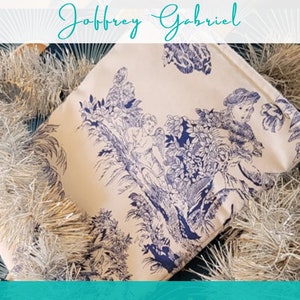 May include: A white fabric tote bag with a blue and white floral pattern featuring cherubs and foliage. The bag has a cream background and a blue floral design.