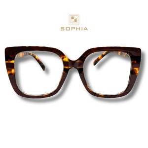 May include: Brown tortoiseshell eyeglasses with a square frame. The glasses have a thick frame and clear lenses. The brand name "SOPHIA" is displayed above the glasses. The glasses are set against a white background.