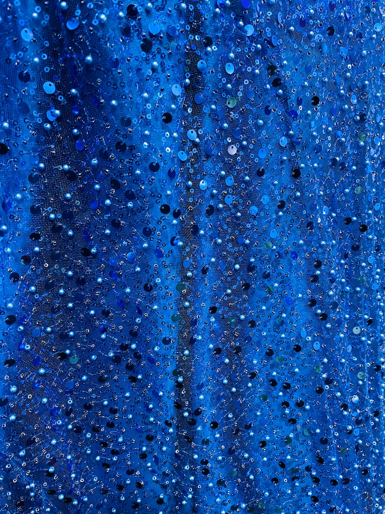 May include: Blue fabric with sequins and beads. The fabric has a shimmery, iridescent look.