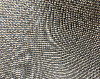 May include: Close-up of a brown fabric with a subtle blue and brown checkered pattern. The fabric has a smooth, slightly shiny texture.