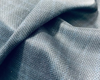 Puede incluir: Primer plano de una tela azul oscuro con un patrón tejido texturizado. La tela es suave y tiene un brillo sutil.