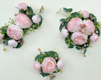 May include: Three arrangements of pink peonies and greenery. Each arrangement is made with artificial flowers and is perfect for adding a touch of elegance to any space.