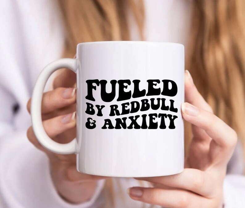 Puede incluir: Taza de cer&aacute;mica blanca con texto negro que dice "Fueled by Redbull & Anxiety".