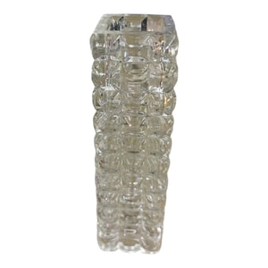 May include: A clear glass vase with a textured, geometric pattern. The vase is square in shape and has a wide opening.