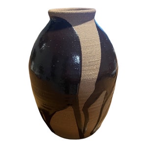 May include: A brown and black ceramic vase with a drip glaze design.