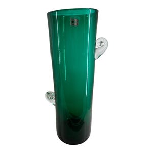 May include: A tall, green glass vase with two clear glass handles on the sides. The vase is shaped like a cactus.