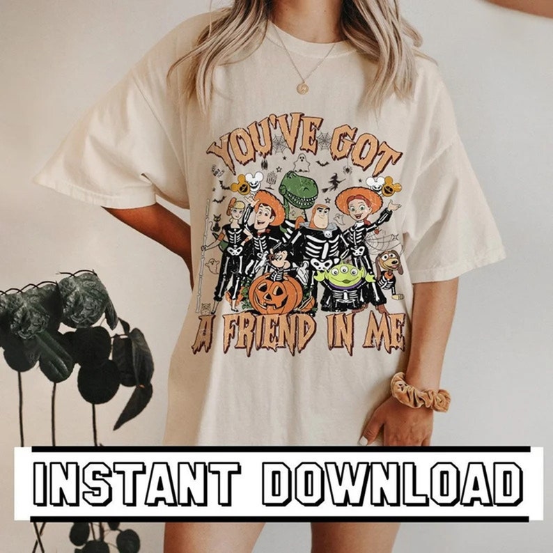 May include: Cream-colored t-shirt featuring a Halloween-themed graphic with the text "YOU'VE GOT A FRIEND IN ME." The design includes cartoon characters dressed as skeletons, a pumpkin, and other spooky elements. The words "INSTANT DOWNLOAD" are at the bottom.