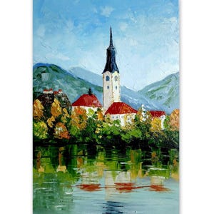 May include: Oil painting of a lakeside village with a tall church steeple. The buildings have red roofs and are surrounded by green trees. The water reflects the buildings and the sky, which is a light blue with white clouds.