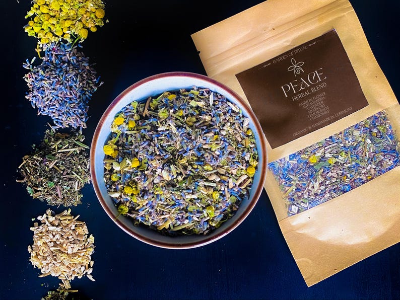 Puede incluir: Un cuenco y un paquete de mezcla de hierbas con el texto "PEACE Herbal Blend". La mezcla contiene hierbas secas azules, amarillas y verdes. Se disponen montones adicionales de hierbas alrededor del cuenco. El paquete enumera ingredientes como la flor de la pasi&oacute;n y la lavanda.