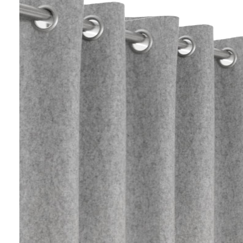 A close-up view of a custom gray wool curtain panel featuring a sleek silver grommet top heading on a rod. The deep eyelet folds highlight the thick, single-layer 2mm wool felt construction. These easy-to-hang drapes are perfect for a boys' bedroom, dorm room, or as a modern room divider. Available in custom sizes including extra-long and extra-wide, these luxury handmade curtains offer a clean, polished finish for contemporary window coverings and industrial-style interiors.