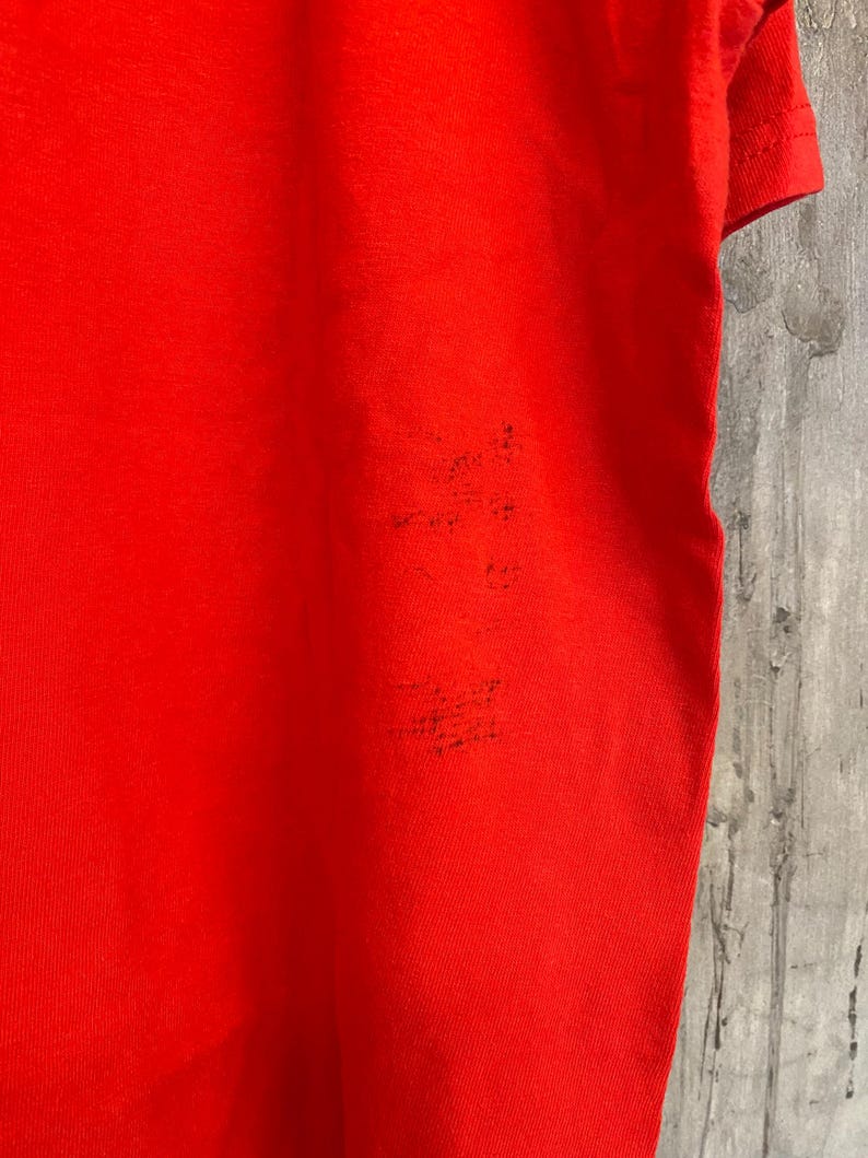 K&ouml;nnte beinhalten: Ein einfarbiges rotes T-Shirt mit kurzen &Auml;rmeln. Das Shirt ist aus einem weichen, bequemen Material.