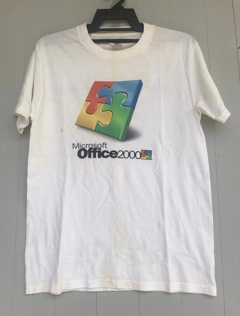 May include: White t-shirt with a Microsoft Office 2000 logo. The logo features a colorful puzzle piece design.