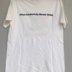 May include: White t-shirt with the text "What Productivity Means Today" printed on the back.