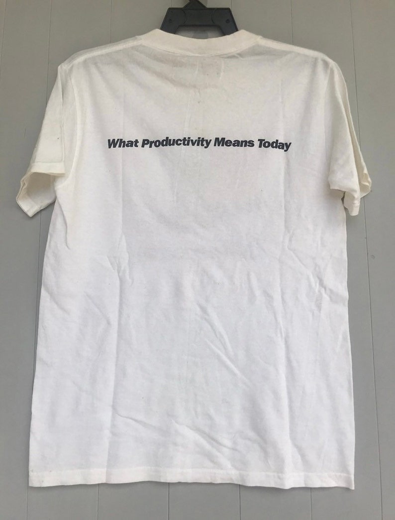 May include: White t-shirt with the text "What Productivity Means Today" printed on the back.