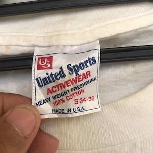 May include: White tag with blue text that reads "United Sports Activewear Heavy Weight Preshrunk 100% Cotton S 34-36 Made in U.S.A."
