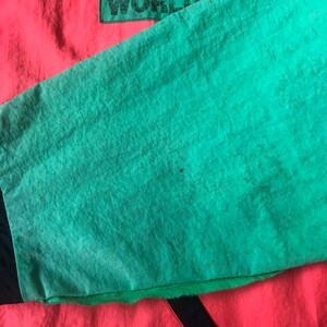 May include: A red, black, and green jacket with the text "JAMS WORLD" on the back.