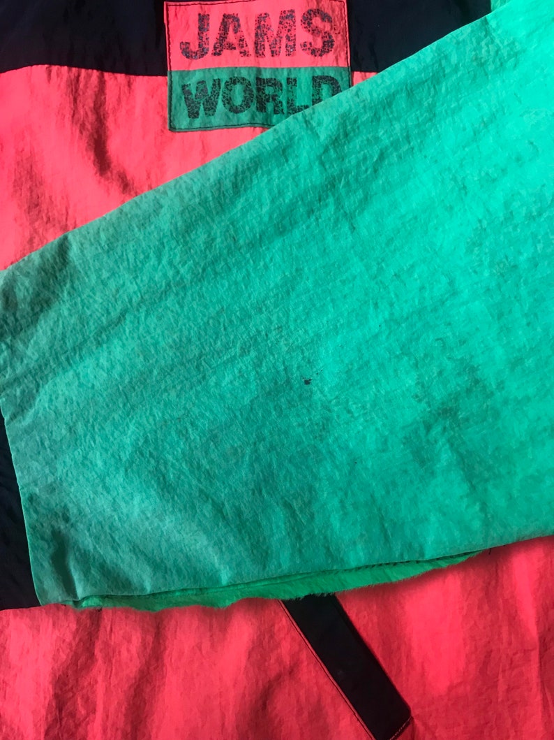 May include: A red, black, and green jacket with the text "JAMS WORLD" on the back.