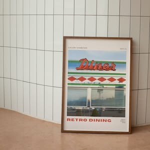 以下が含まれることがあります： レトロなダイナーをテーマにした額装されたポスター。ポスターには「Diner」と書かれた赤いネオンサインと、青い空が見える大きな窓が描かれています。ポスターの下部には「Retro Dining」というテキストが印刷されています。