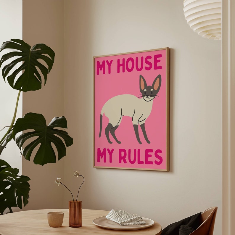 K&ouml;nnte beinhalten: Ein rosa-wei&szlig;es Poster mit einer Cartoon-Siamesenkatze und dem Text "My House My Rules".