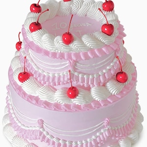 May include: A three-tiered pink cake decorated with white frosting and red cherries. The cake has a ruffled edge and the words "10 years" are written on the top tier. A festive dessert for a celebration.