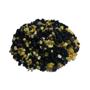 Peut inclure: Un petit tas arrondi de matériau granulaire en vrac composé d'un mélange de minuscules cailloux noirs brillants et irréguliers et de perles résineuses translucides de couleur jaune pâle, blanc cassé et ambre clair à la surface texturée.