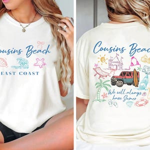 Op de afbeelding: Cr&egrave;mekleurig T-shirt met de tekst "Cousins Beach East Coast" in blauw schrift. De voorkant heeft illustraties met strandthema. De achterkant van het shirt heeft extra strandtekeningen en de zin "We will always have Summer."
