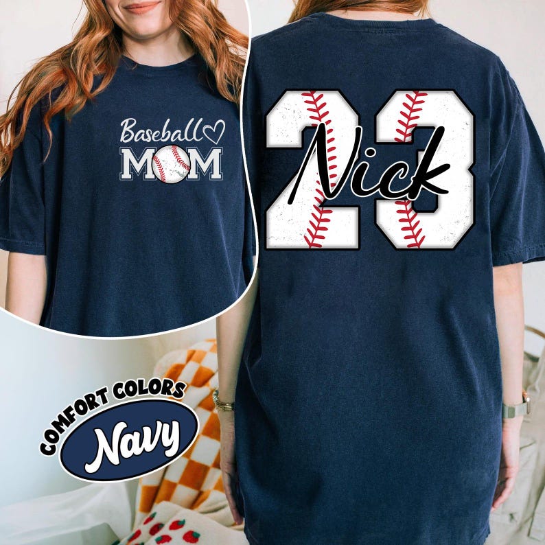 May include: Navy blue t-shirt with a baseball graphic and the text "Baseball Mom" on the front. The back of the shirt has a baseball graphic with the number 23 and the name "Nick" written in a script font.