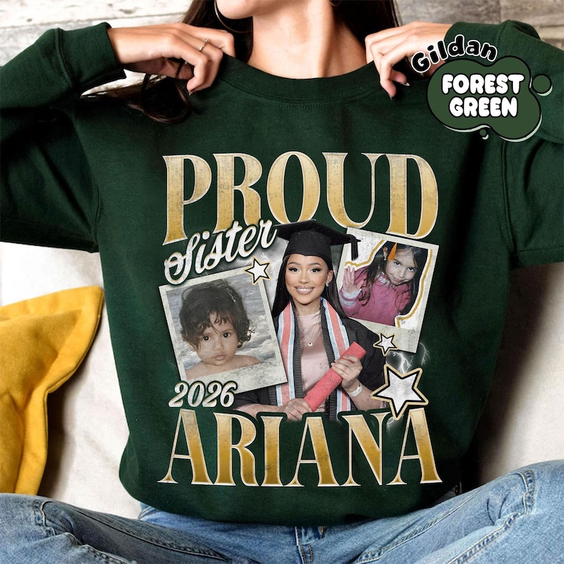 Puede incluir: Sudadera verde bosque con la inscripci&oacute;n dorada "PROUD sister". El dise&ntilde;o incluye tres fotos enmarcadas, el nombre "ARIANA" en dorado y el a&ntilde;o "2026".