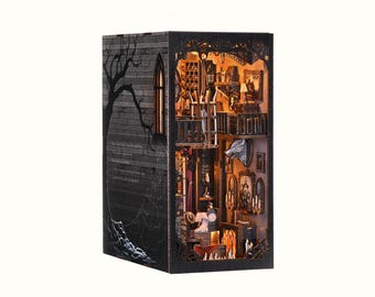 Puede incluir: Una casa de muñecas de madera en miniatura con un diseño gótico. La casa de muñecas está iluminada desde el interior y presenta un interior detallado con muebles, una chimenea y una cabeza de lobo colgada en la pared. La casa de muñecas está rodeada de un marco negro con un diseño de telaraña.