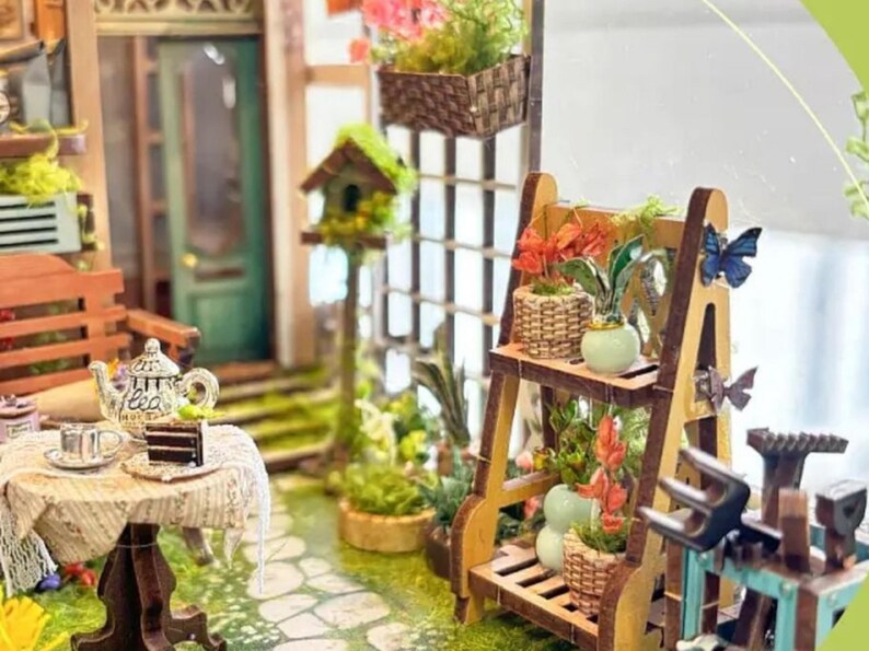 May include: A miniature dollhouse scene with a wooden porch, a small table with a teapot and teacups, and a wooden plant stand with potted plants and a butterfly.
