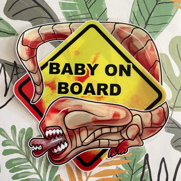 May include: A sticker featuring a yellow diamond-shaped sign with the black text BABY ON BOARD. A beige and red creature with an elongated head, sharp teeth, and a protruding inner jaw wraps around the sign, which has red splatter accents.