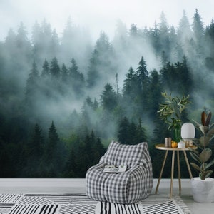 May include: A foggy forest scene with a gray and white checkered bean bag chair in the foreground. The chair is sitting on a white and black patterned rug. There is a small table with a potted plant and a lamp next to the chair.