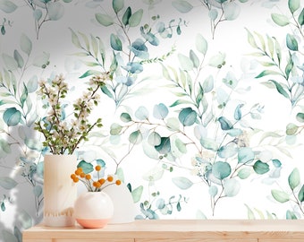 May include: White wallpaper with a repeating pattern of watercolor green and blue leaves. A wooden shelf with two white ceramic vases and a small vase with orange berries is in the foreground.