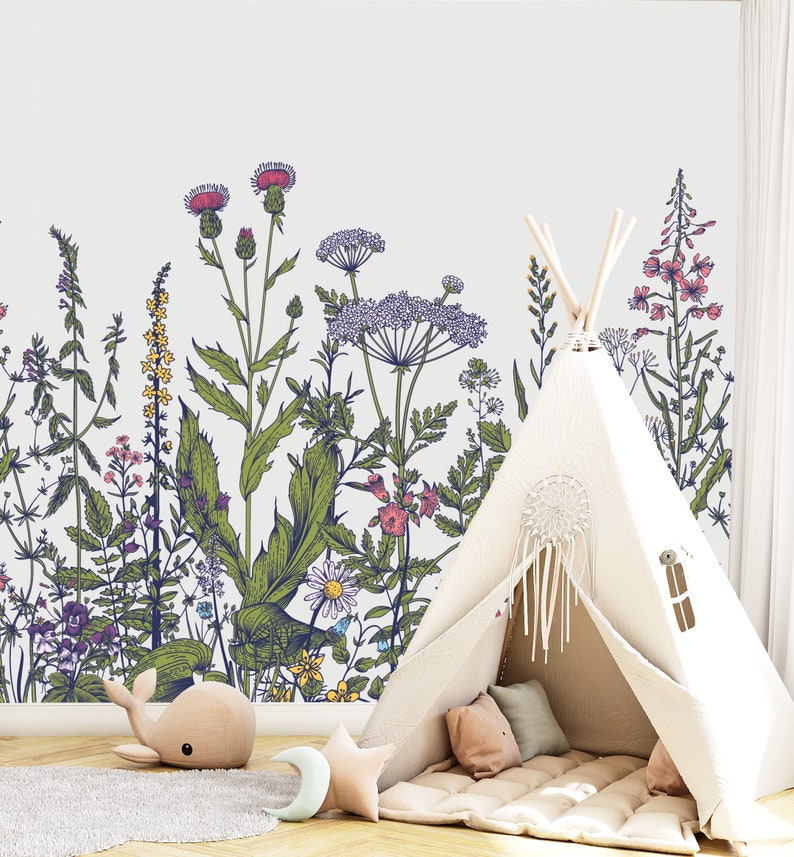 May include: A white teepee tent with a brown floor mat and pillows inside. The teepee is set up in front of a wall with a floral pattern of green leaves and pink, purple, and yellow flowers.