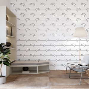 Puede incluir: Papel tapiz blanco con un patr&oacute;n repetitivo de dibujos de l&iacute;nea negra de gatos durmiendo en una l&iacute;nea. El papel tapiz est&aacute; en una habitaci&oacute;n con una estanter&iacute;a blanca, un banco gris, una silla gris y una l&aacute;mpara.