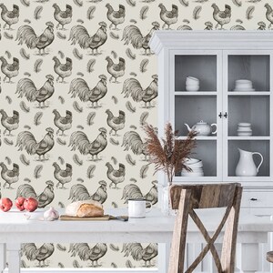 May include: A white kitchen with a white cabinet with glass doors. The cabinet is filled with dishes and a pitcher. The wall behind the cabinet is covered in a wallpaper with a pattern of roosters and feathers.