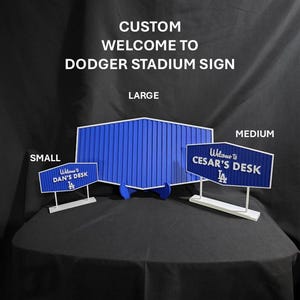 May include: Custom blue and white "Welcome to Dodger Stadium" signs in small, medium, and large sizes. The signs feature the text "Welcome to Dan's Desk" and "Welcome to Cesar's Desk" on the smaller signs.