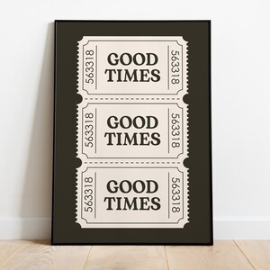 以下が含まれることがあります： 濃い茶色の背景に「GOOD TIMES」と書かれた白いチケットが3枚ある、黒枠のプリントです。