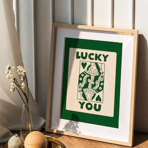 Puede incluir: Una impresi&oacute;n enmarcada con un fondo verde y una tarjeta blanca con una ilustraci&oacute;n de carta de juego de la reina de corazones y el texto "LUCKY YOU".