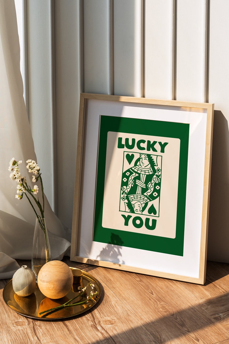 Puede incluir: Una impresi&oacute;n enmarcada con un fondo verde y una tarjeta blanca con una ilustraci&oacute;n de carta de juego de la reina de corazones y el texto "LUCKY YOU".