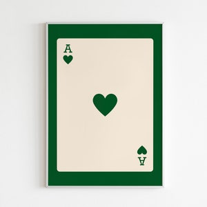 Puede incluir: Una impresi&oacute;n enmarcada de una carta de as de picas con un borde verde y un fondo crema. El as de picas se representa en un estilo minimalista con un coraz&oacute;n verde en el centro y la letra A en la parte superior e inferior.